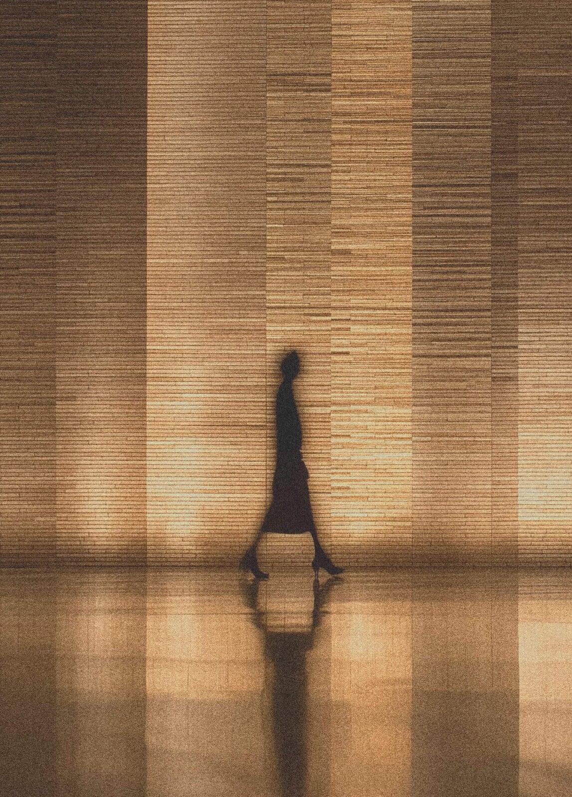 Silhouette of a professional investor walking through a high-end, modern lobby, representing elite asset management.